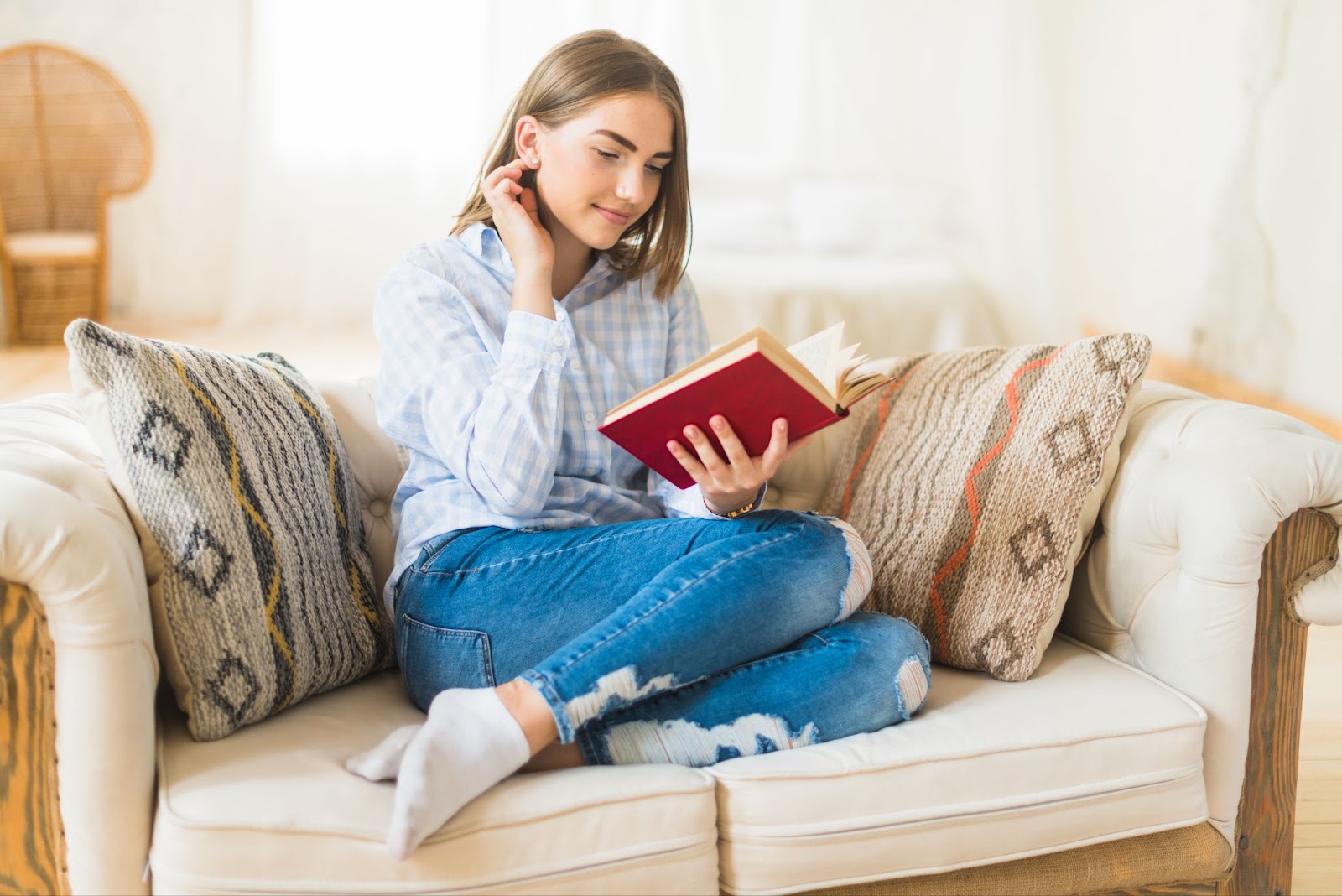 The girl is smiling and reading a book