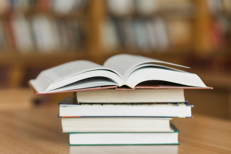 an open book on top of a stack of books