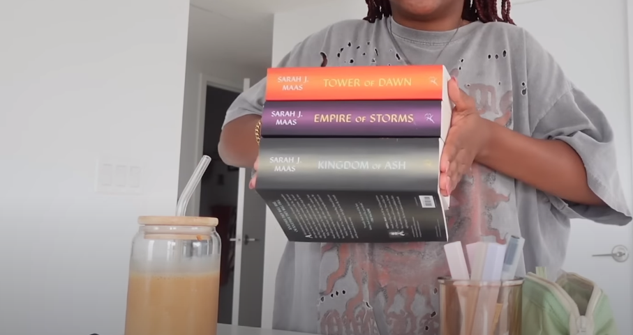 Woman holding three books from The Throne of Glass series